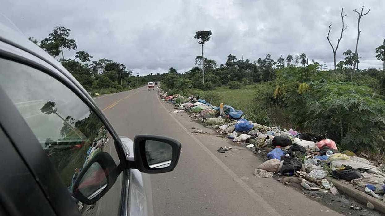 A view from a vehicle of garbage on the side of the road in the Amazon