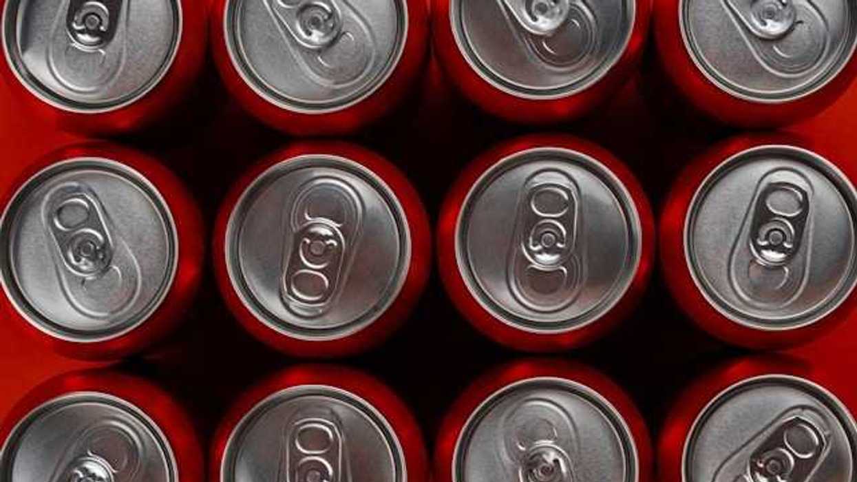 A view from above of rows of red soda cans