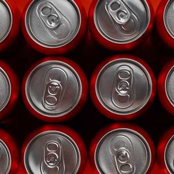 A view from above of rows of red soda cans