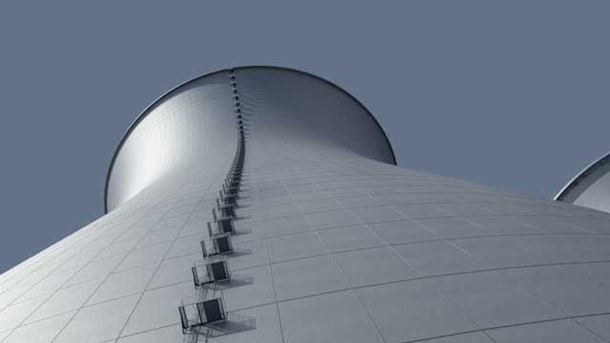 A view from below of a power cooling tower against a blue sky