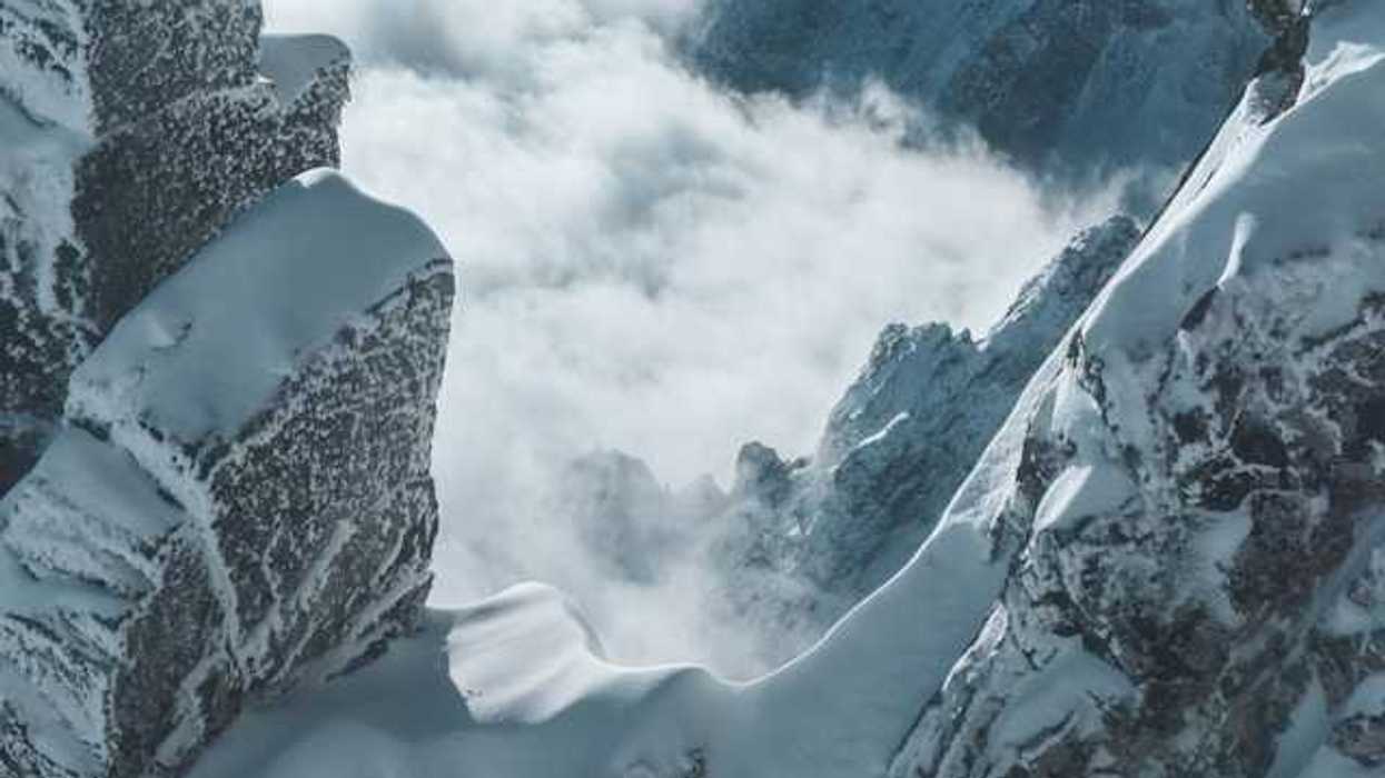 A view into the corridor of a snowy mountain with fog in the distance
