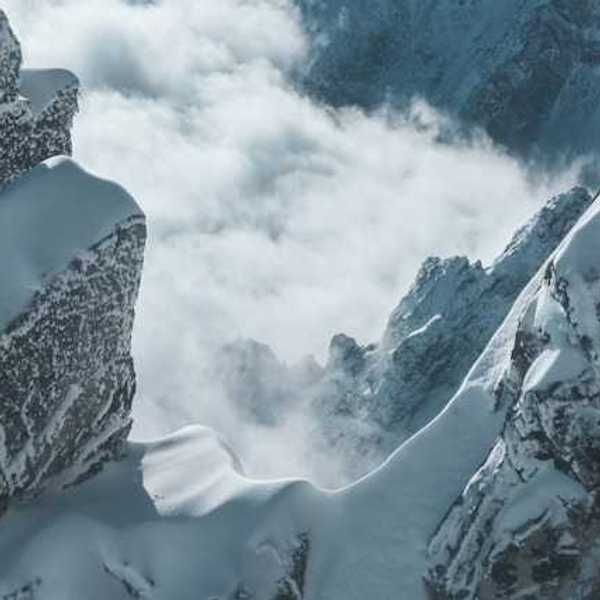 A view into the corridor of a snowy mountain with fog in the distance