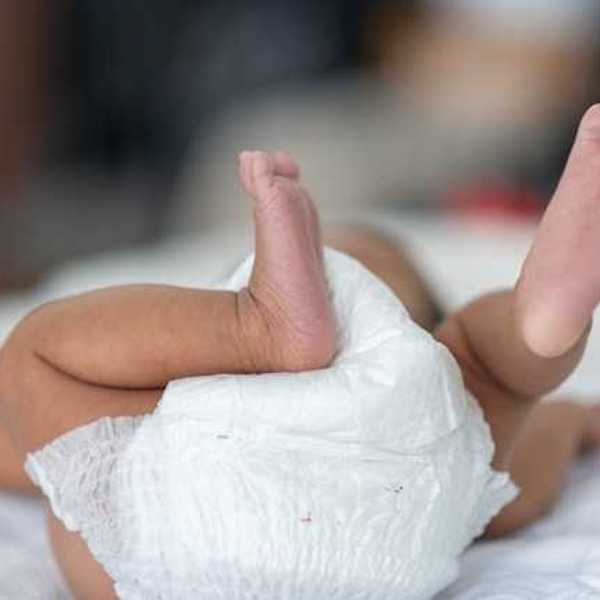 A view of a baby on its back wearing a diaper