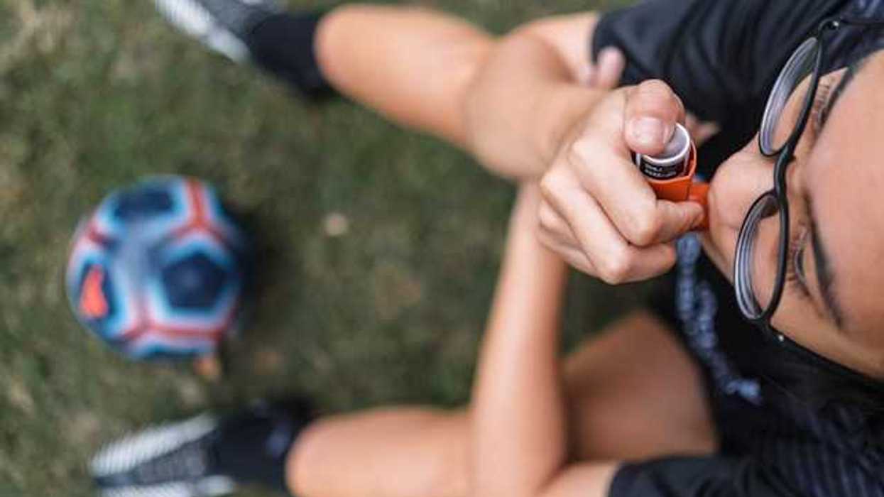 A view of a child on a soccer field with an asthma inhaler