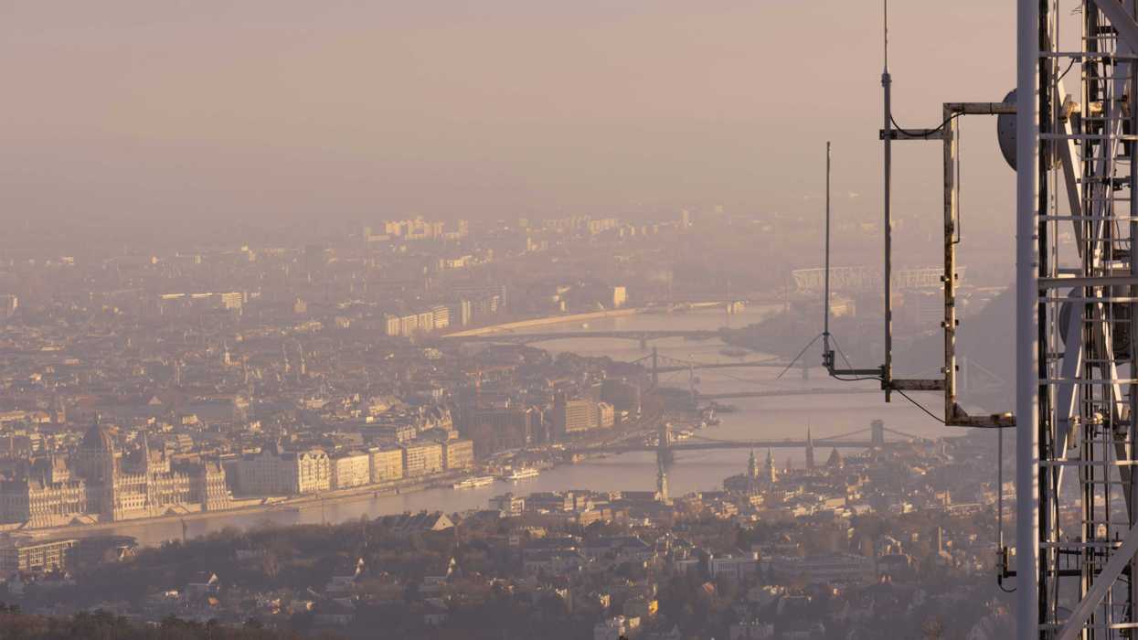 a view of a city shrouded in smog from a tall building.
