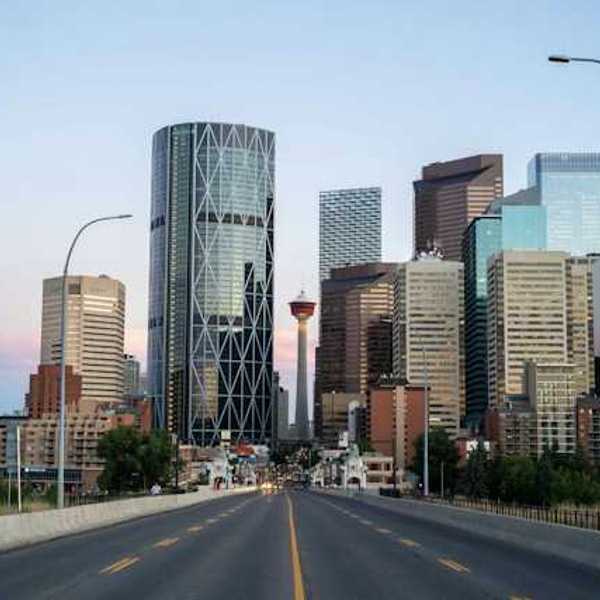 A view of a city skyline with a freeway heading toward it