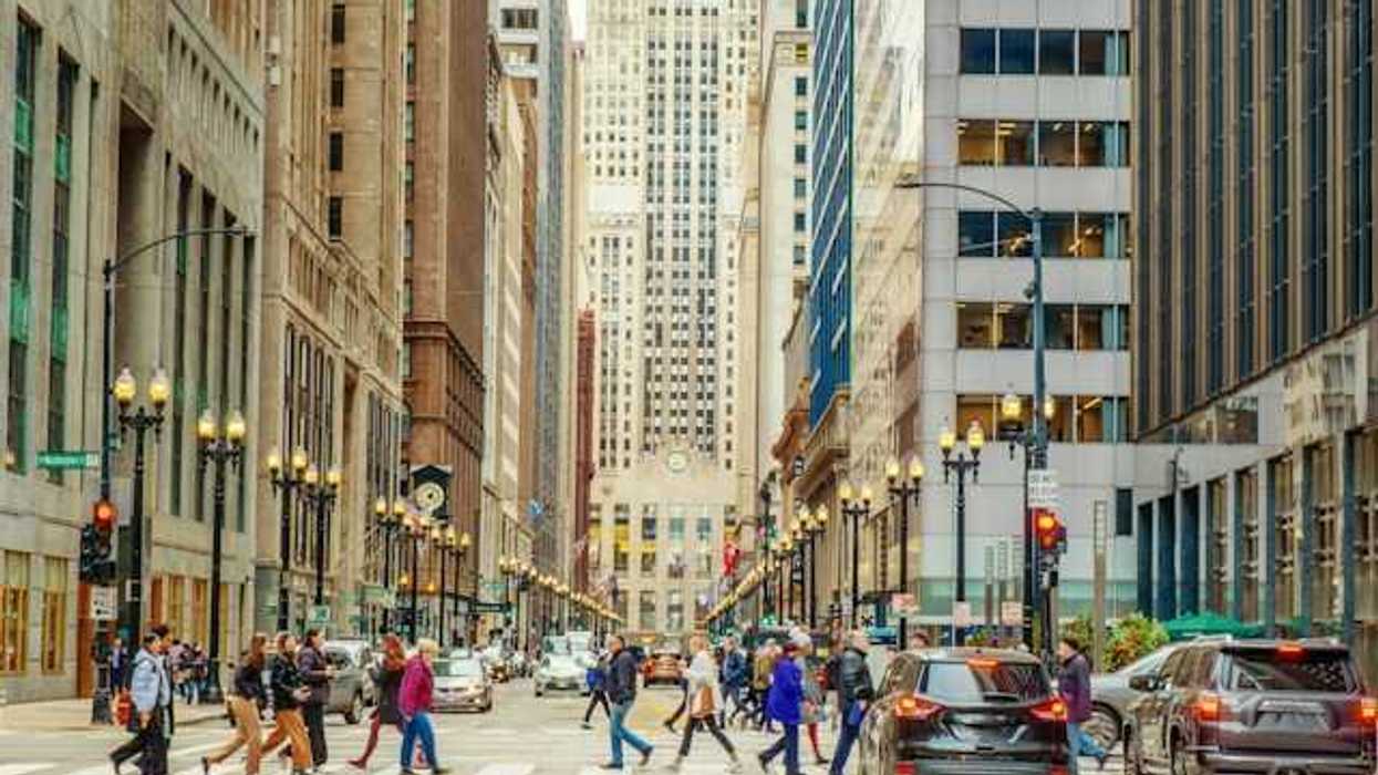 A view of a city street with cars and tall buildings