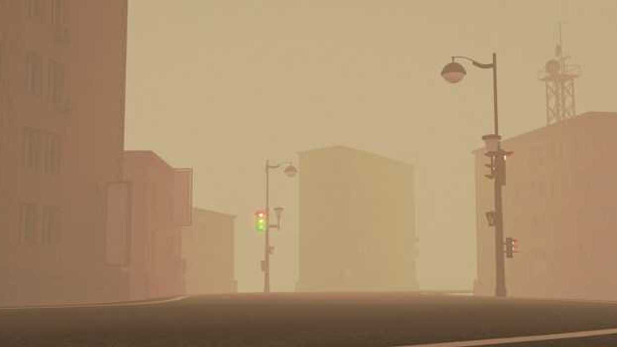 A view of a city street with smog or smoke in the air