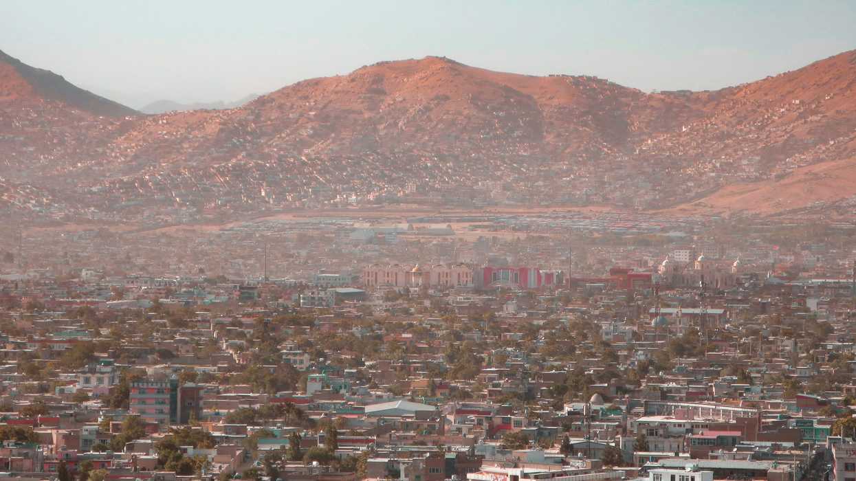 a view of a city with dry mountains in the background.