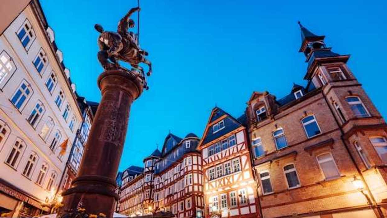 A view of a European square with half-timbered houses and a status of a man on a horse