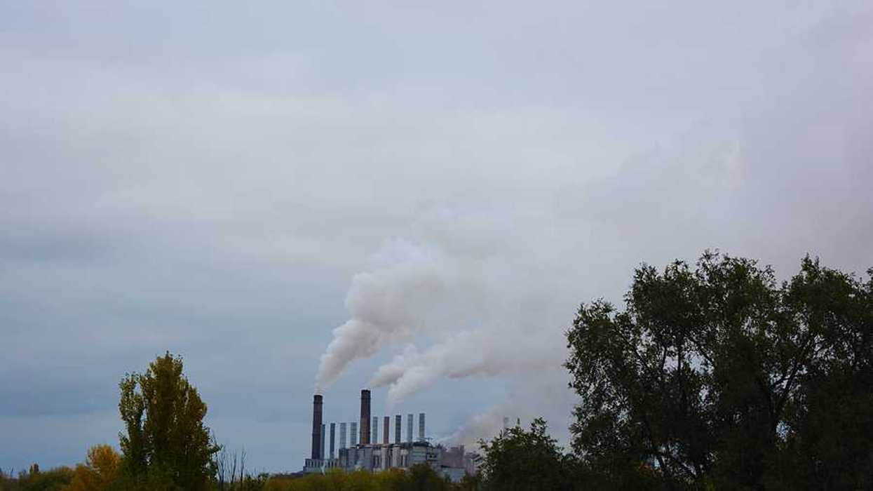 A view of a factory with smoke spewing into the air