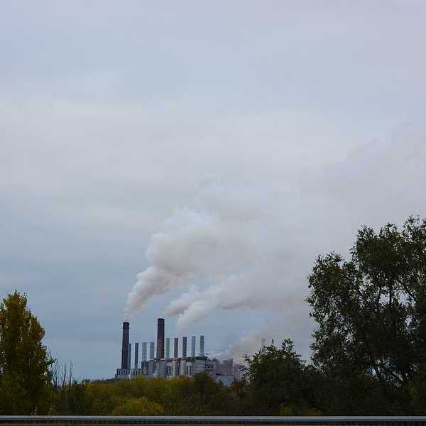 A view of a factory with smoke spewing into the air