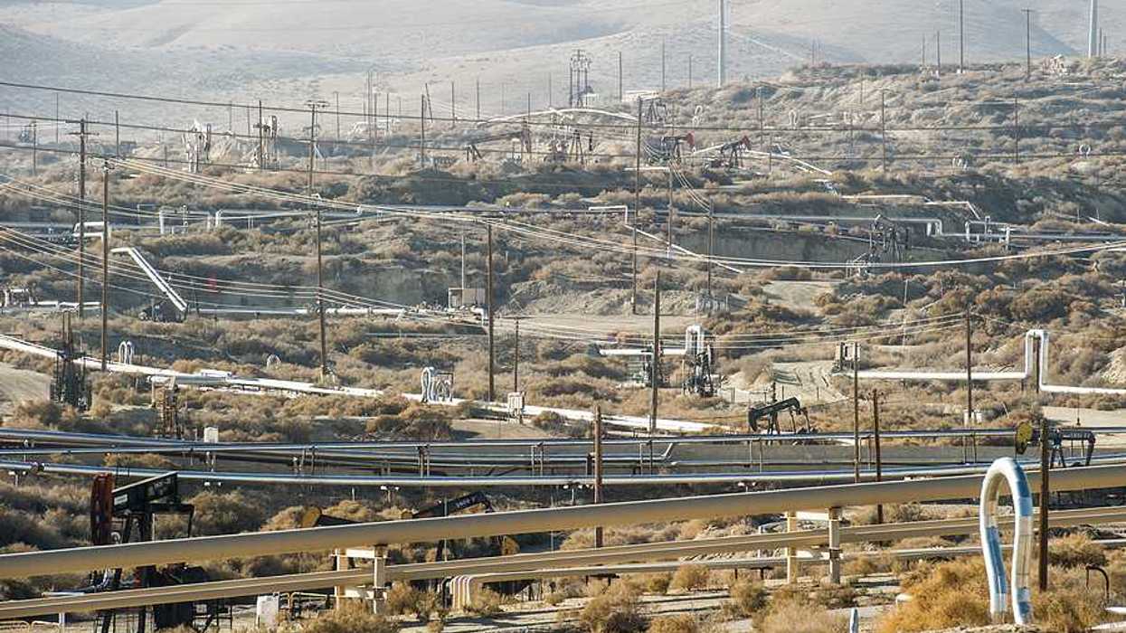 A view of a field of oil pump jacks in a dry environment
