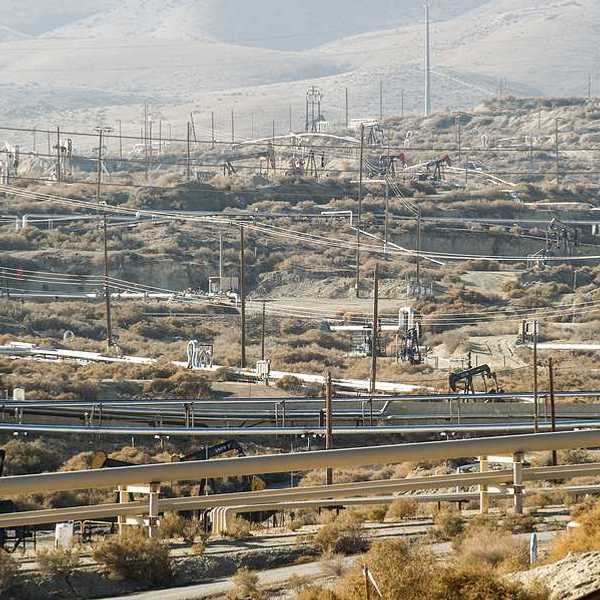 A view of a field of oil pump jacks in a dry environment
