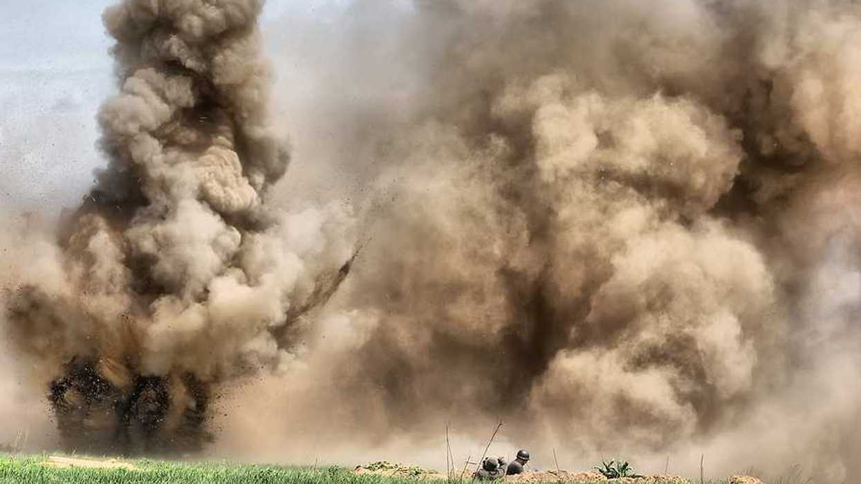 A view of a field under attack with bombs exploding