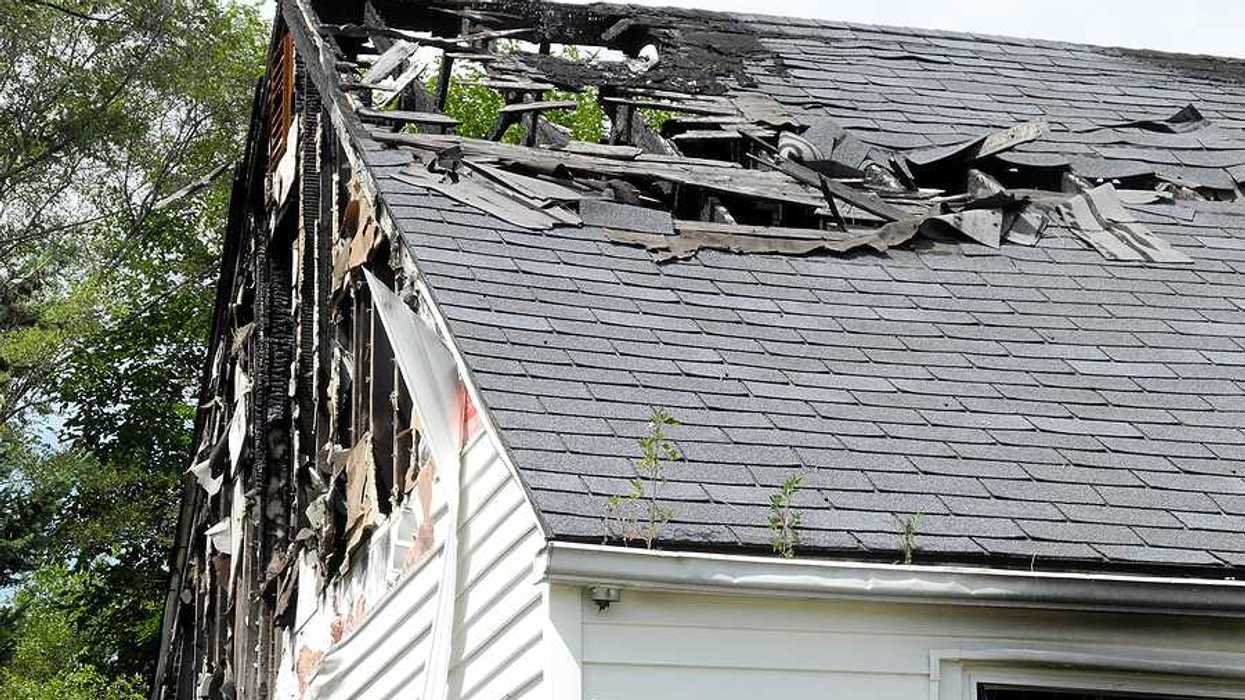 A view of a house roof that is partially burned