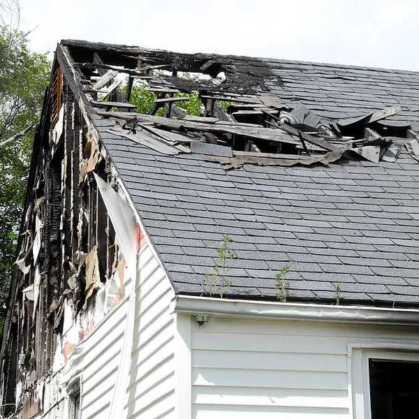 A view of a house roof that is partially burned