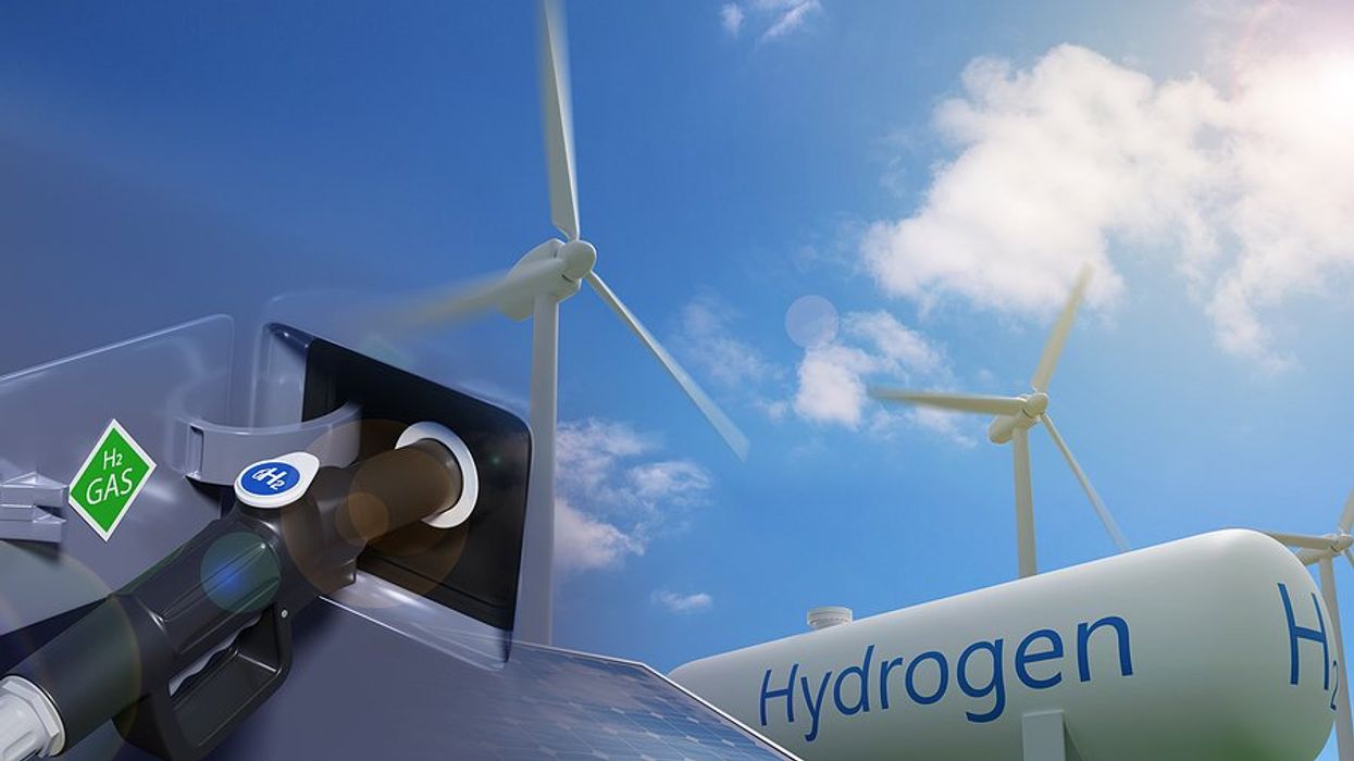 a view of a hydrogen car being charged with wind turbines and a solar panel in the background