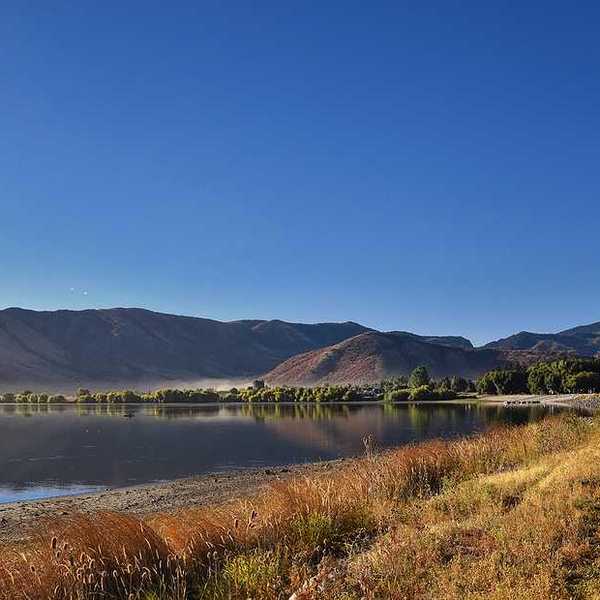 A view of a lake with dry mountains in the background