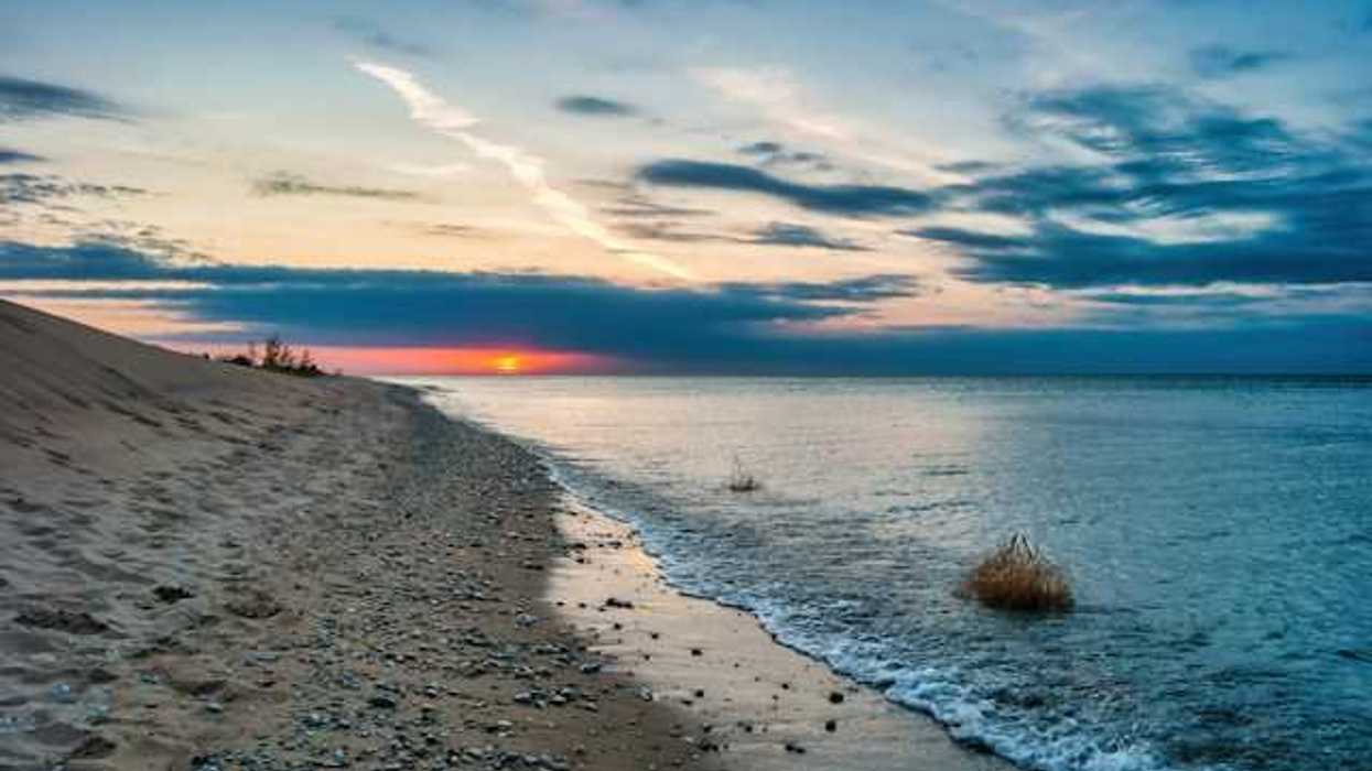 A view of a lake with the setting sun in the distance