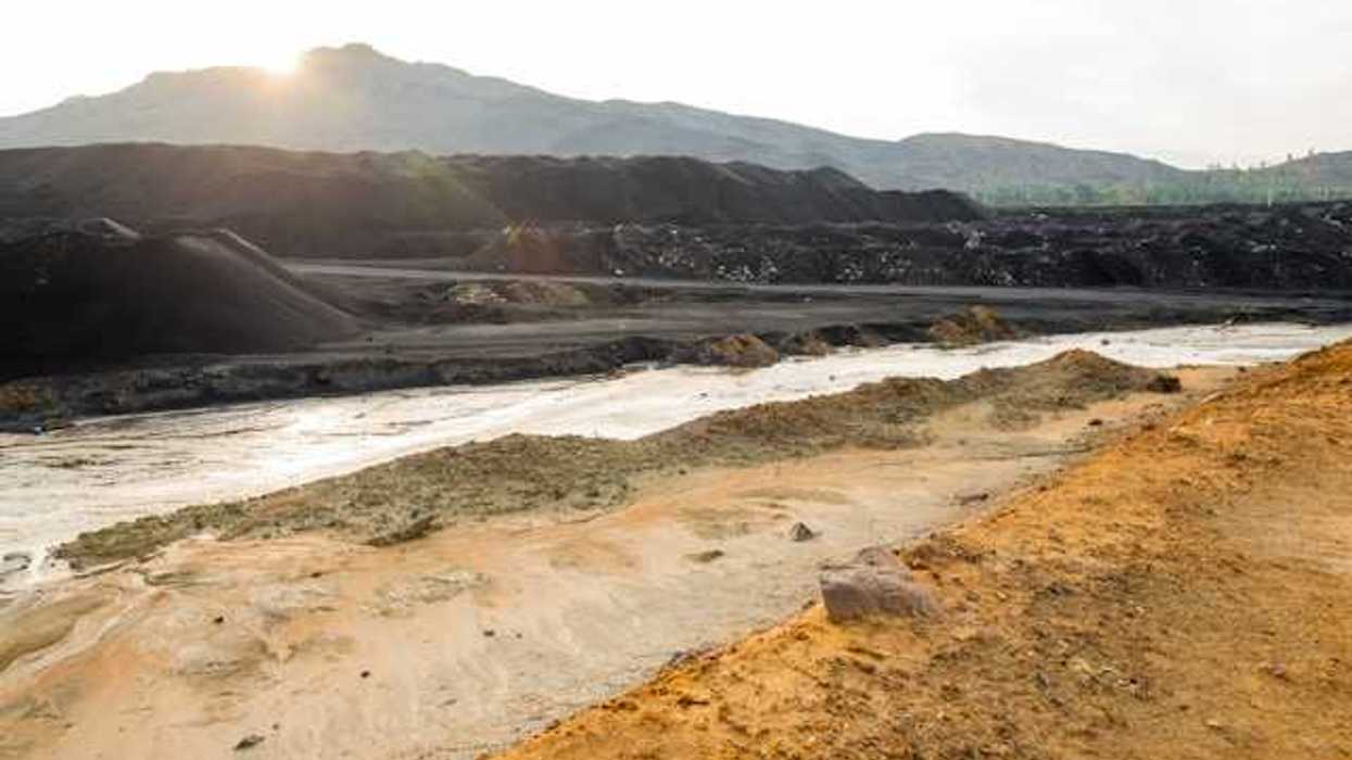 A view of a mining pit with a river in the foreground