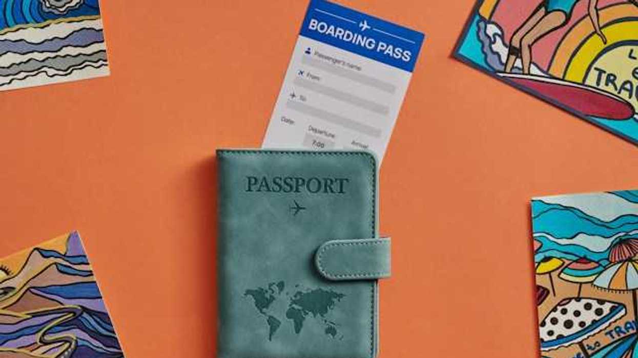 A view of a passport cover and boarding pass against an orange background