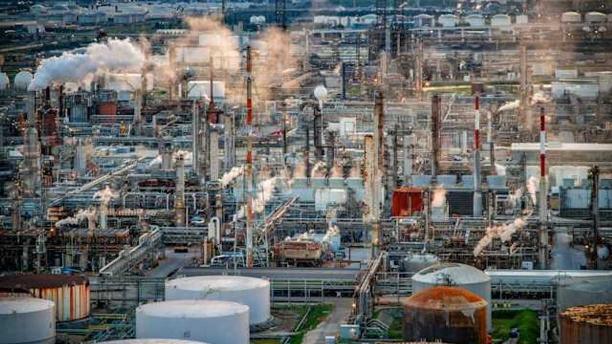 A view of a petrochemical plant with the skyline of a city in the background