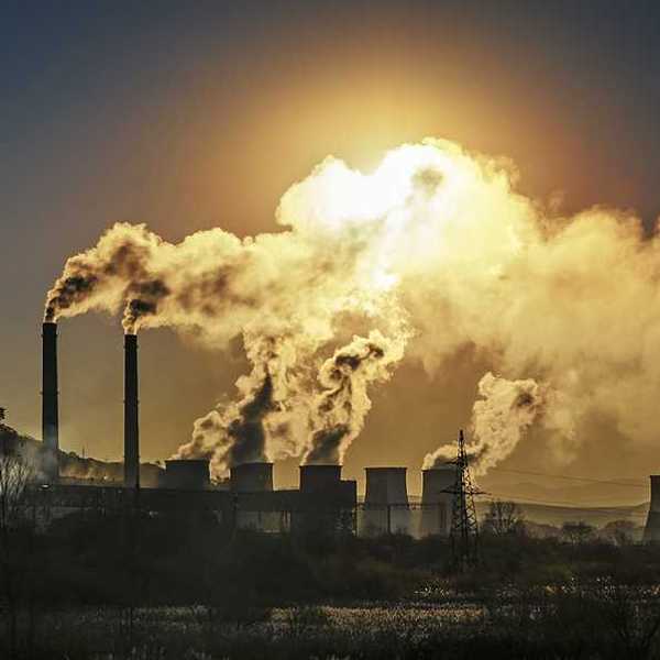 A view of a power station with air pollution streaming into the sky