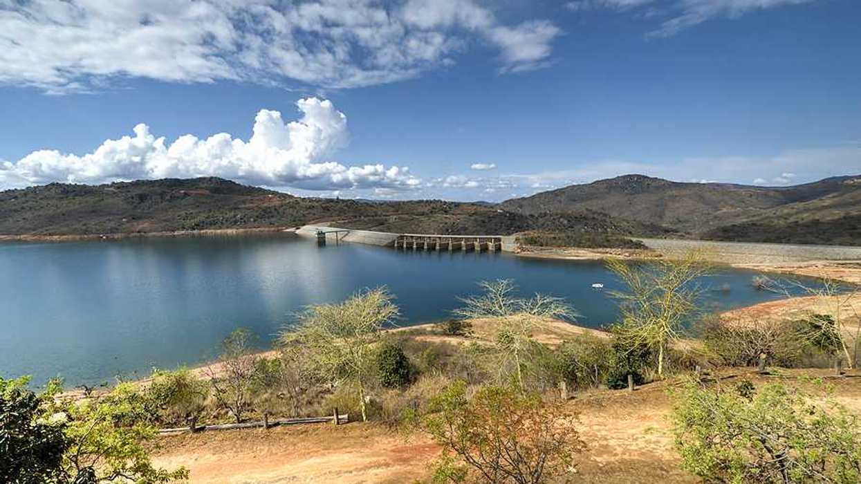A view of a reservoir and dam with dry land surrounding it