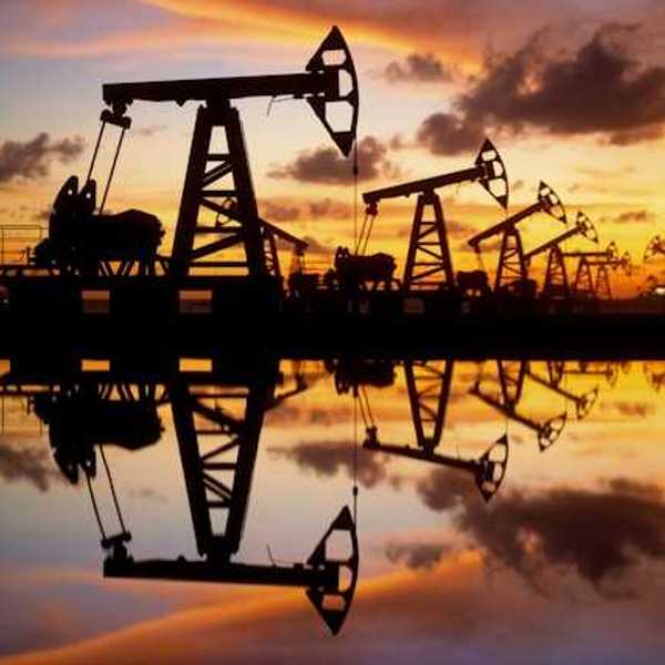 A view of a row of oil pump jacks with a beautiful sunset in the background