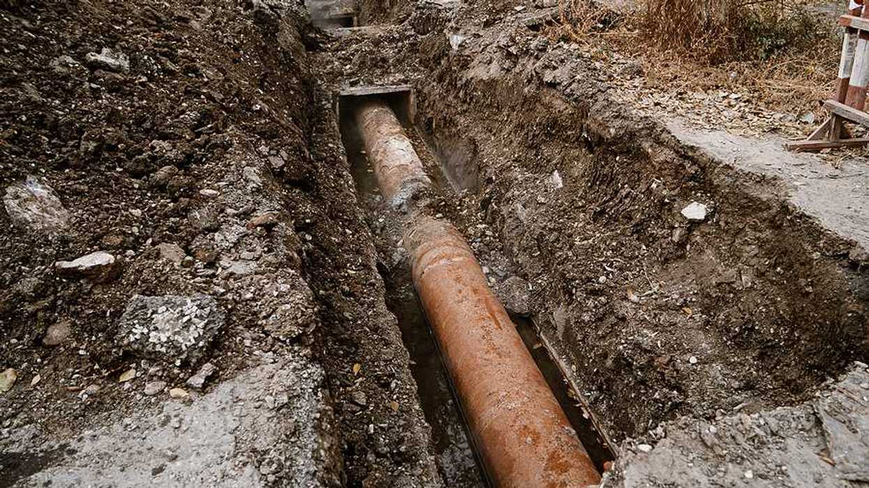 A view of a rusty pipe in a trench