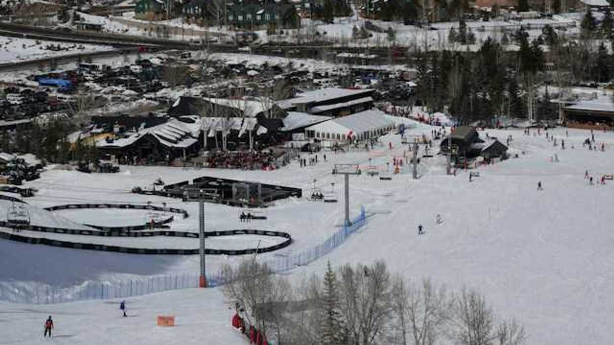 A view of a ski resort with people skiing down a hill