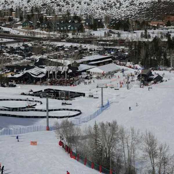 A view of a ski resort with people skiing down a hill