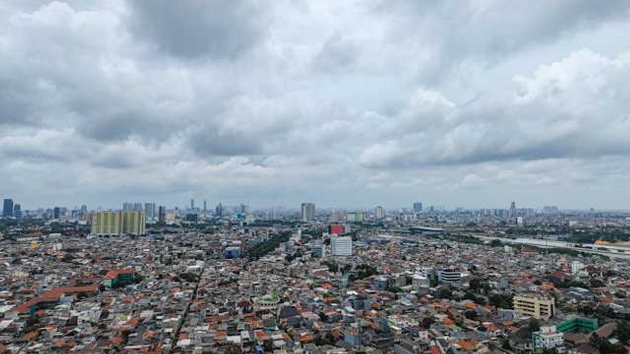 A view of a sprawling city with dark clouds on the horizon