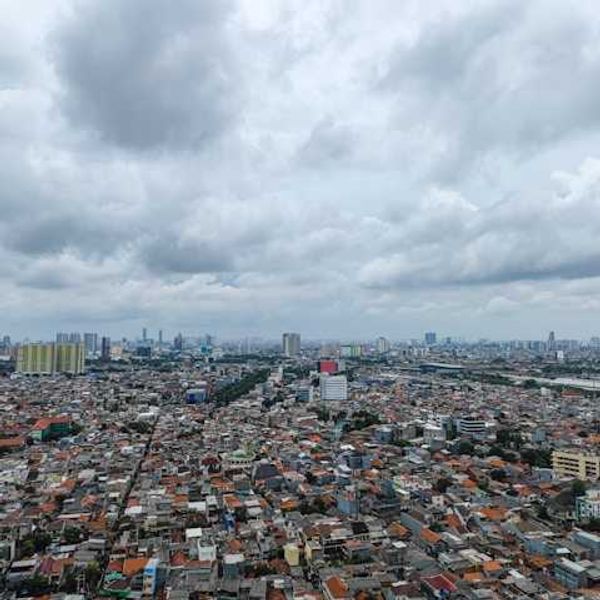 A view of a sprawling city with dark clouds on the horizon