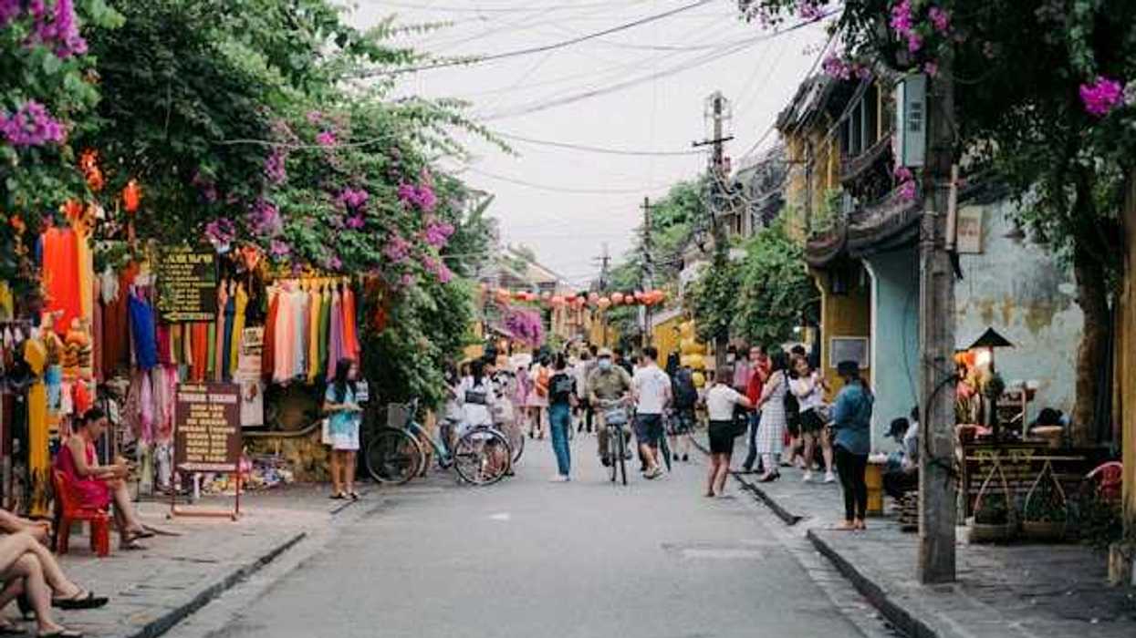 A view of a street with lots of flowering vines growing on the houses