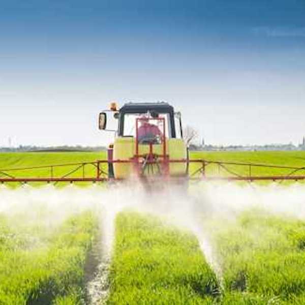 A view of a tractor applying pesticides to a field