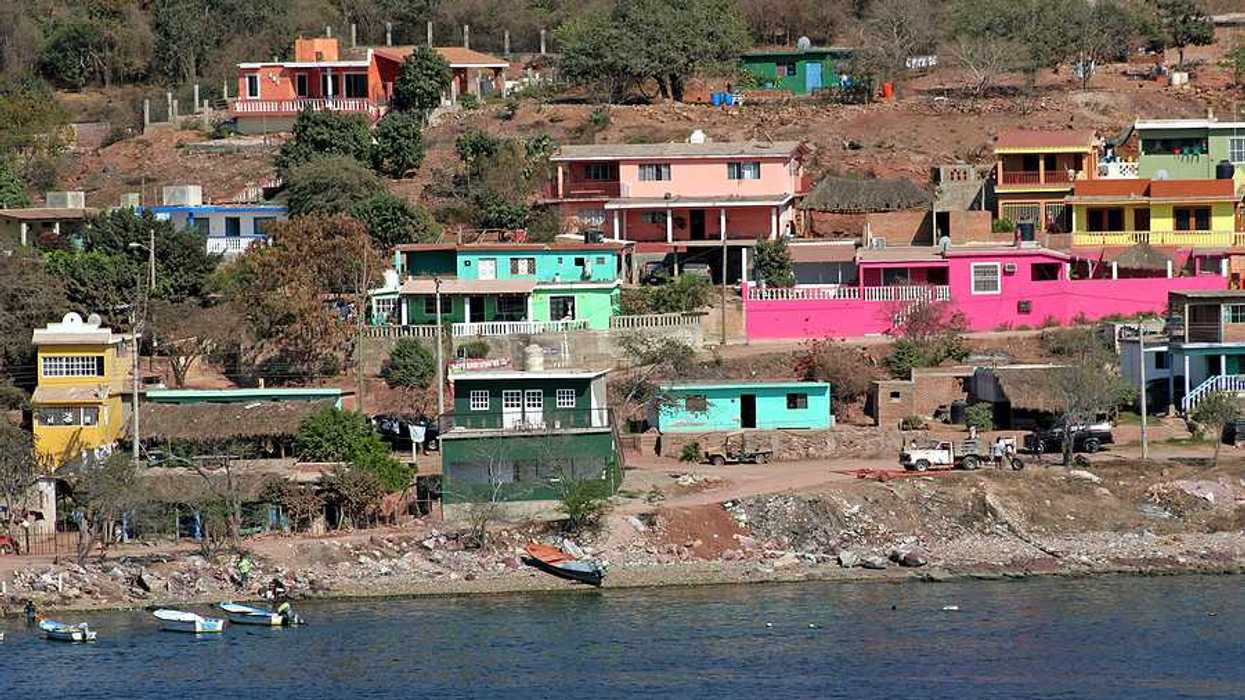 A view of a village on hills above the ocean