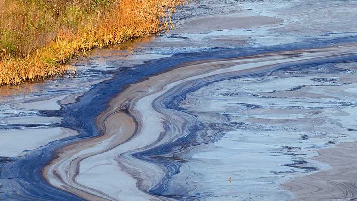 A view of a water source with oil floating on the surface