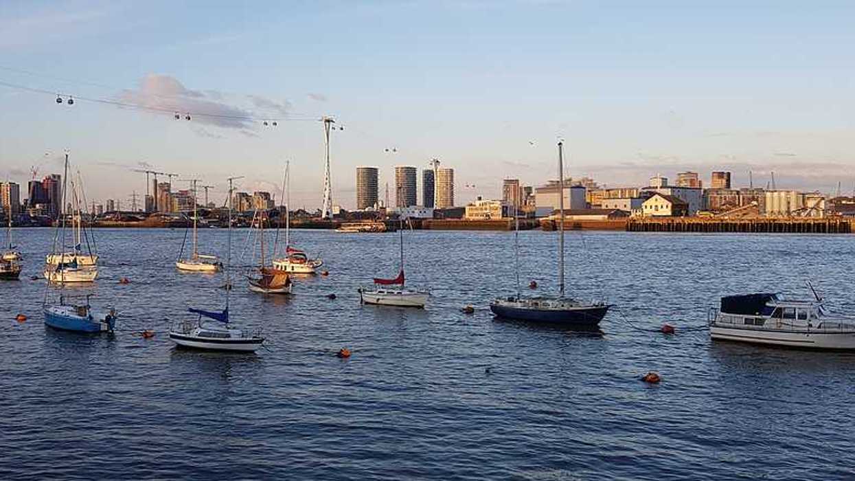A view of boats floating on the Thames with buildings in the background