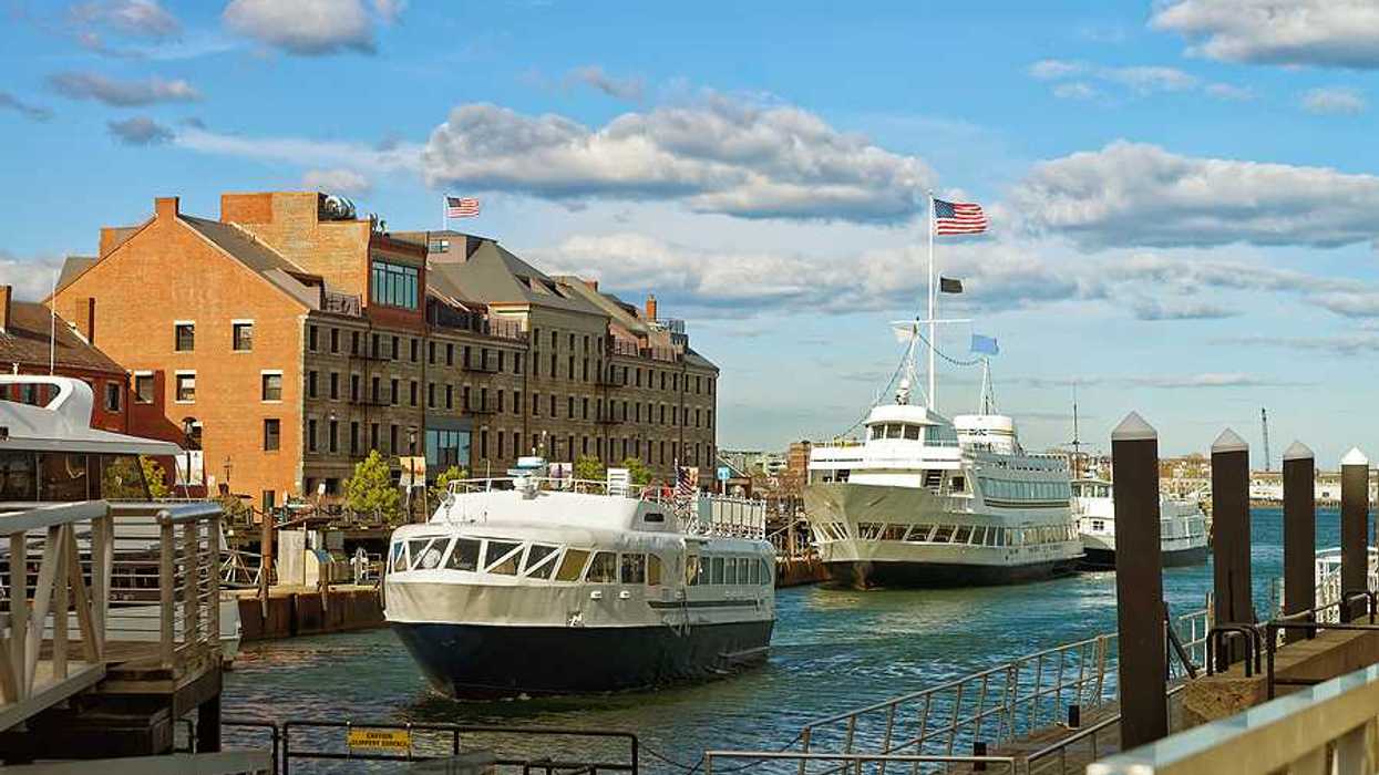 A view of Boston Harbor with ferries nearing a dock