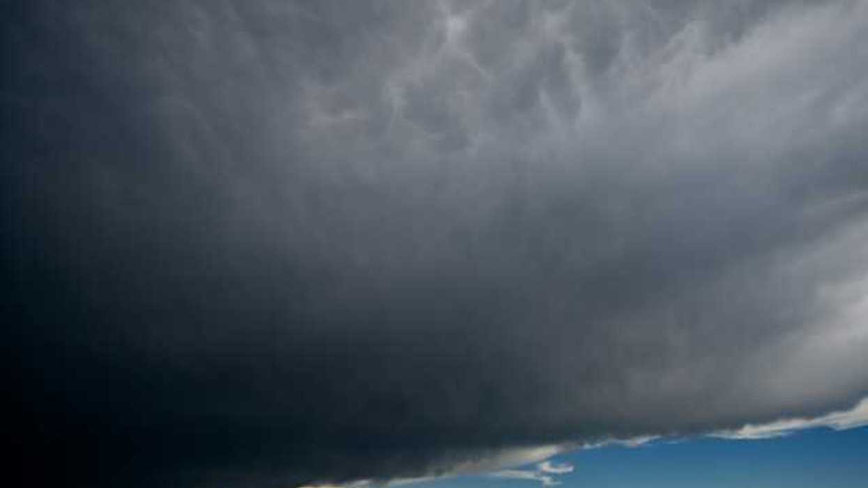 A view of dark storm clouds with blue skies in the background