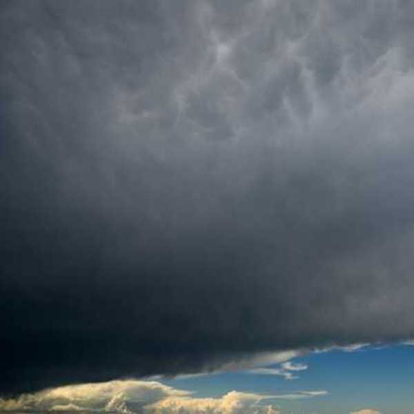 A view of dark storm clouds with blue skies in the background