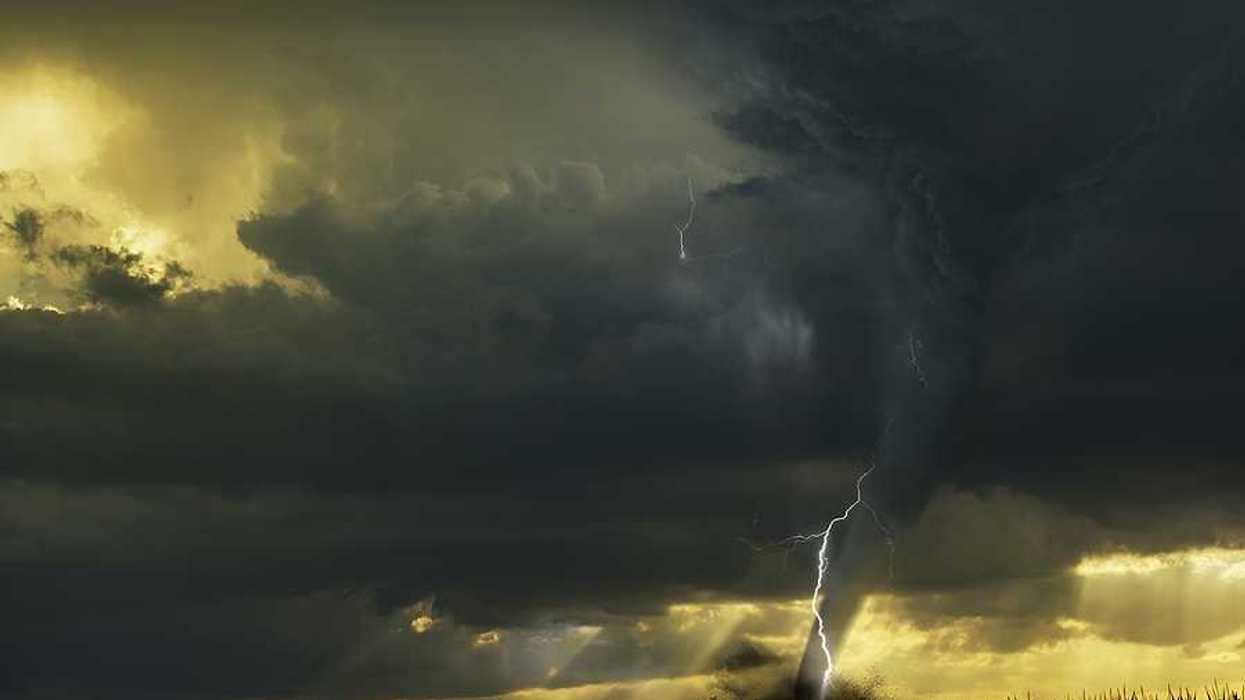 A view of dark storm clouds with lightning and a tornado forming