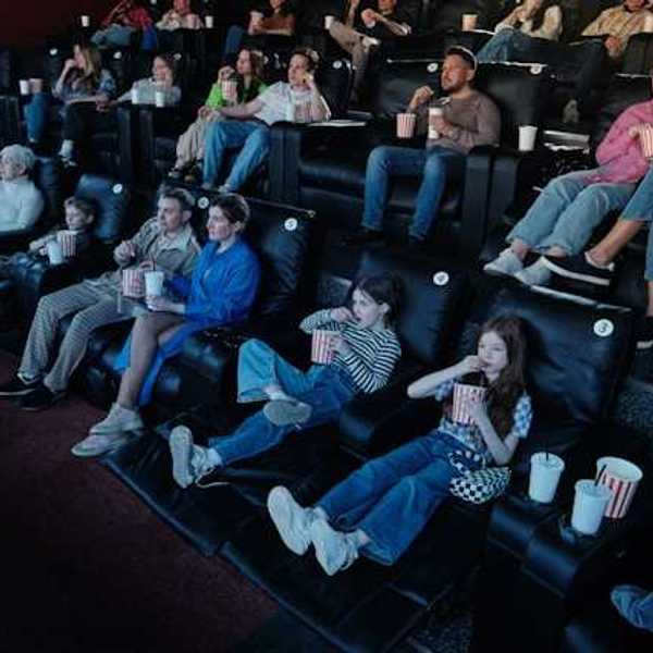 A view of people sitting in a movie theater watching a movie
