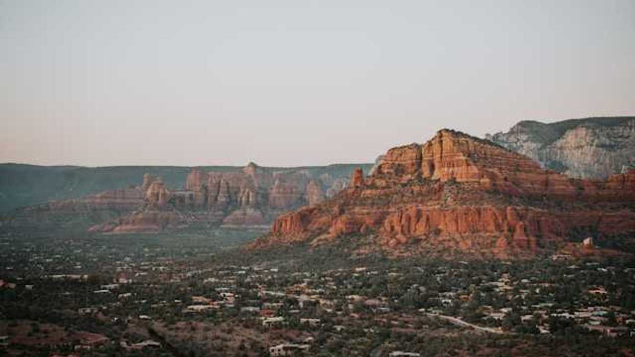A view of red buttes with a town on the plain below them