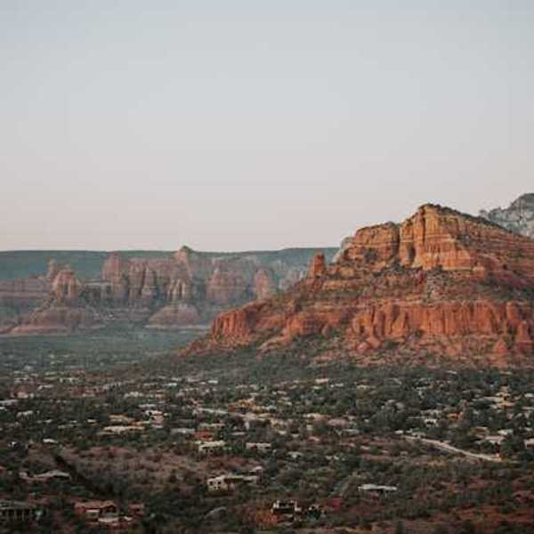 A view of red buttes with a town on the plain below them