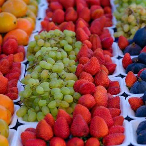 A view of rows of fruit such as grades, strawberries and plums