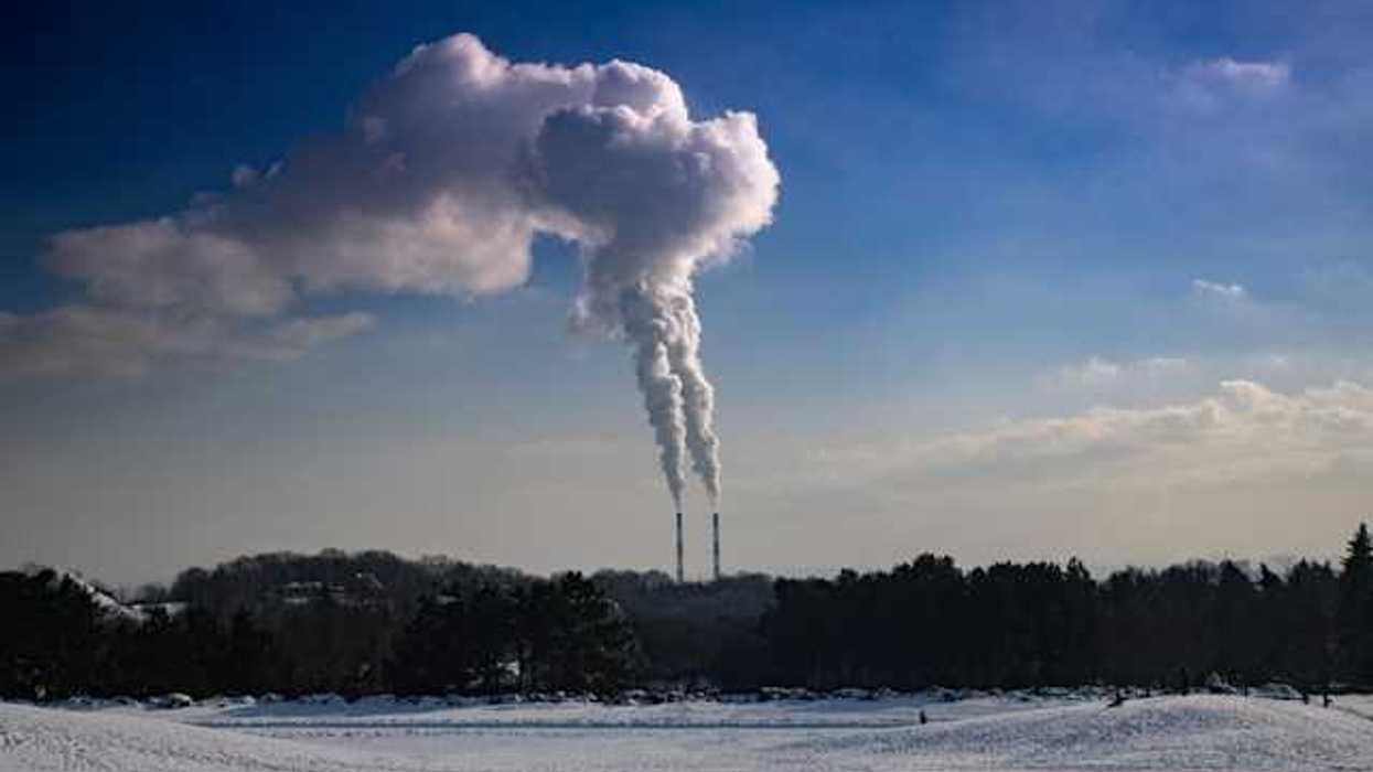A view of smokestacks with pollution coming out of the top