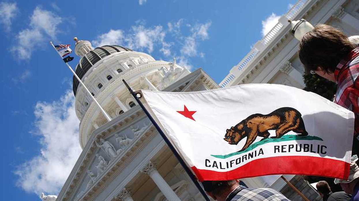 A view of the California flag flying next to the California capitol building